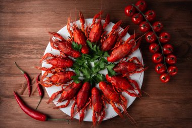 Çeri domatesli, acı biberli ve otlu bir tabakta kerevit.