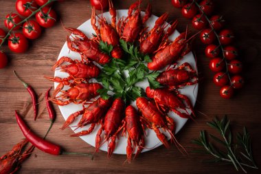 Çeri domatesli, acı biberli ve otlu bir tabakta kerevit.