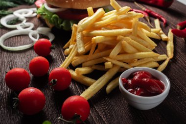 Tahta bir arka planda patates kızartması yığınının yakın çekimi.