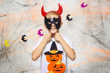 Bir çocuk Cadılar Bayramı balkabağıyla oynuyor.