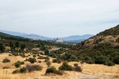 Geniş bir manzara tepeleri, kuru otlakları ve dikkat çekici bir mimariye sahip uzak bir kasabayı sergiliyor. Açık gökyüzü bu kırsal bölgenin huzurlu atmosferini arttırır..