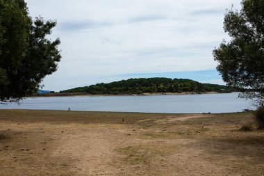 Gün batımında yumuşak tepelerle çevrili tenha bir gölün huzur dolu güzelliğini hissedin. Durgun su, solgun ışığı yansıtır. Huzuru ve yansımayı çağırır. Ziyarete gelen herkese..