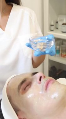 Yetenekli bir profesyonel, sakin bir spa ortamında müşterilerin yüzüne yatıştırıcı bir tedavi uygular. Atmosfer sakin, yumuşak müzik rahatlama deneyimini arttırıyor..