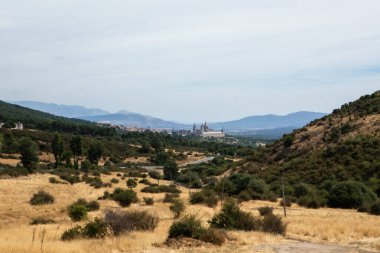 Geniş bir manzara tepeleri, kuru otlakları ve dikkat çekici bir mimariye sahip uzak bir kasabayı sergiliyor. Açık gökyüzü bu kırsal bölgenin huzurlu atmosferini arttırır..