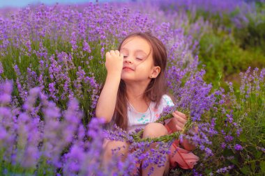 güzel bir küçük kız bir lavanta taç yapar