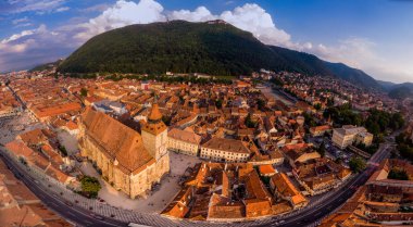 Arka tarafta siyah katedral ve dağ ile Brasov şehir manzarası 