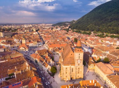 Arka tarafta siyah katedral ve dağ ile Brasov şehir manzarası 