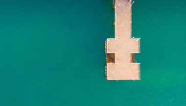 Kumlu plajda hava manzarası. Şemsiyeler, kum, köprü ve 