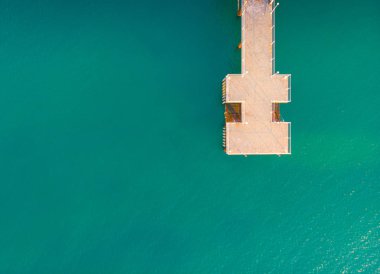 Kumlu plajda hava manzarası. Şemsiyeler, kum, köprü ve 