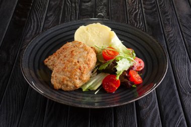 Göğsü patates püresi, salata yaprakları ve domates ile