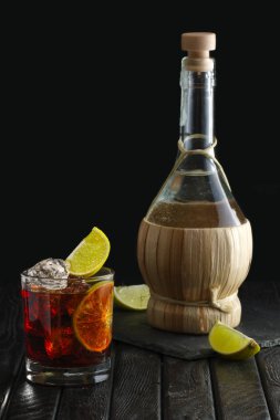 Soğuk votka, kireç ve kahve likör ve şişe üzerinde arka plan ile kokteyl