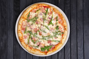 Üstten görünüm pizza jambon, pastırma, roka ve rendelenmiş parmesan peyniri ile