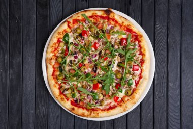 Sosis, salam, zeytin, roka, soğan ve domates ile pizza üstten görünüm