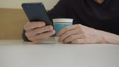 Ücretsiz kablosuz 4 g kullanarak kafede oturan iş molası sırasında son haberler okuma internet'te sörf adamın elini internet