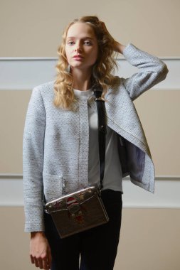 Sevimli öğrenci kız ceket, kot pantolon ve bot ile omuz çantası ondoors