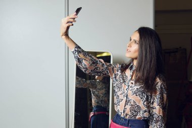 Güzel kız göstermek için hazırlık sırasında selfie yapma. Model makyaj ve saç ile sahne arkasında hazır Başlarken.