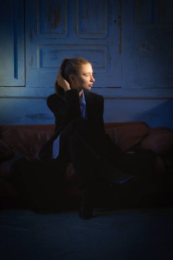 Yumuşak odak spot ile vurgulanan karanlık odada güzel kız portresi. (küçük bir gürültü fotoğraf içerir)