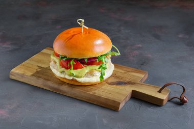 Kesme tahtası boşaltmak ile lezzetli ızgara biftek burger marul, peynir ve soğan ile servis