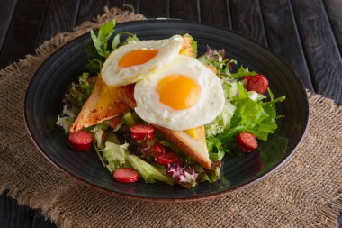 Kızarmış yumurta tost, eritilmiş peynir ve salata yaprakları ile 