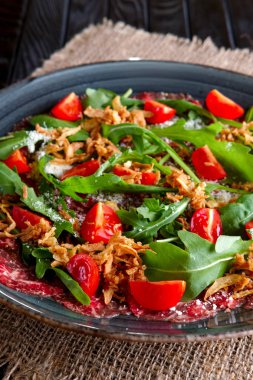 Dana carpaccio kiraz domates, roka ve derin kızarmış domuz pastırması