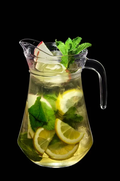 Lemon, apple and mint cold lemonade in pitcher isolated on black background