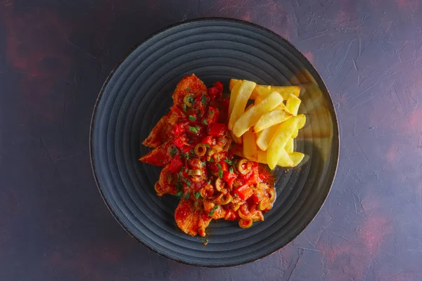 Portuguese  goulash with tomato and olives sauce and fried potato