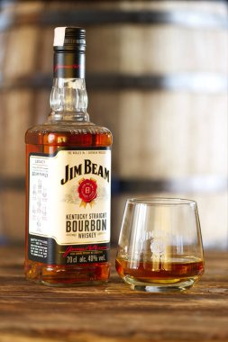28 Mart 2019, Minsk, Beyaz Rusya - kentucky düz bourbon viski varil üzerinde arka plan ile ahşap masa üzerinde cam şişe