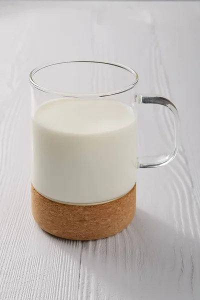 白い木製の台所のテーブルのミルクのガラス — ストック写真