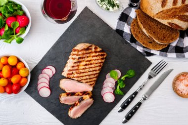 Taze sebze ve kırmızı şarap bir bardak ile taş tahta üzerinde ızgara sığır biftek orta nadir. Yukarıdan görüntüle.