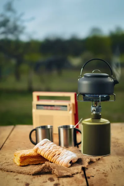 Making coffee or tea on portable gas stove on the nature. Travel, adventure, camping gear, outdoors items.
