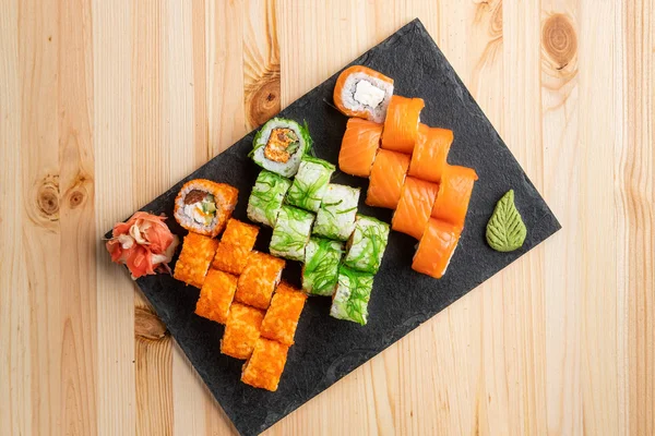 Set di rotoli con wasabi e zenzero sottaceto su tavola da portata in pietra — Foto Stock