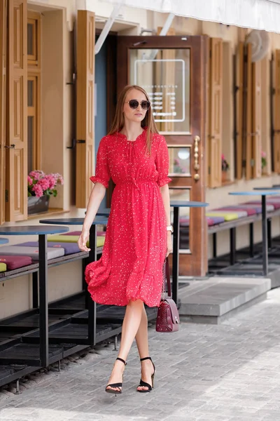 Chica bonita en vestido rojo caminando por la calle en el casco antiguo — Foto de Stock