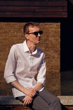 Güneş gözlüğü orta yaş adam sıcak güneşli bir günde gölgede oturan