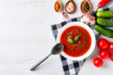 Ahşap arka planda fesleğen, biber, sarımsak ve salatalık ile Domates çorbası. İspanyol gazpacho çorbası.