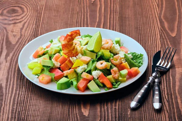 Ensalada con aguacate, queso feta y camarones sobre mesa de madera vieja —  Fotos de Stock