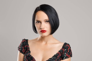 Stüdyoda poz kısa koyu saçlı ve kırmızı dudakları ile Ciddi bayan