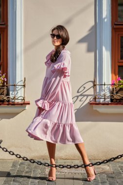 Büyük boy pembe elbiseli genç güzel şık kız Açık kentsel portre