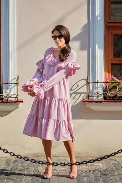 Retrato urbano al aire libre de joven hermosa chica elegante en vestido rosa de gran tamaño — Foto de Stock