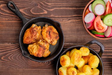 Kavrulmuş tavuk uyluk, kızarmış patates ve salata - rustik akşam yemeği