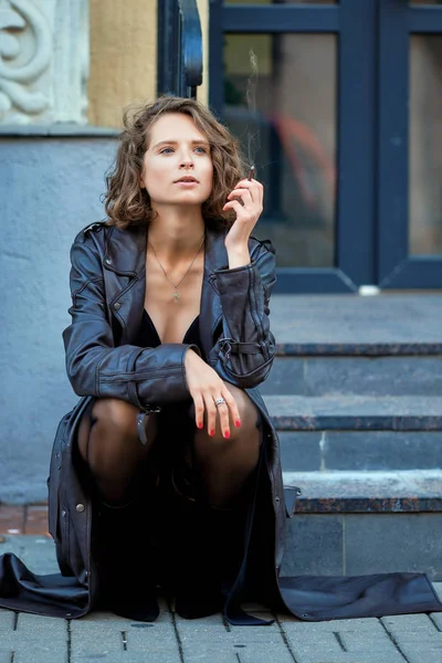 Kunstporträt einer schönen Dame mit Zigarette, die auf der Veranda sitzt — Stockfoto