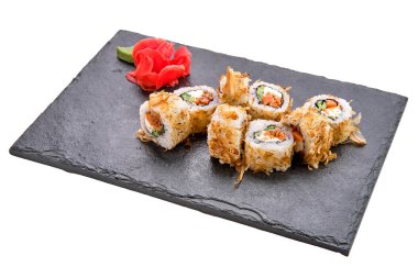 Beyaz tabaktaki salatalıklı tütsülenmiş somon ruloları.