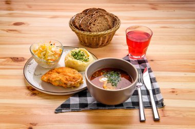 Rustik akşam yemeği - tavuk fileto, patates püresi ve lahana turşusu tuzlu çorba, kahverengi ekmek ve bir bardak kızılcık suyu.