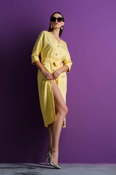 Modèle de mode en grandes lunettes de soleil portant une robe jaune avec boutons détachés — Photo