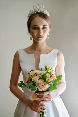 Güzel gelinin portresi, elinde bir buket çiçekle.