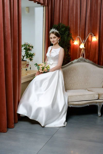 Όμορφη Νύφη Υπέροχο Φόρεμα Κάθεται Στον Καναπέ Δίπλα Στο Παράθυρο — Φωτογραφία Αρχείου