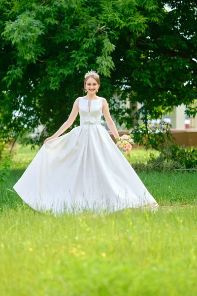 Portrait of pretty bride with coronet in hair outdoor near ceremony pavilion