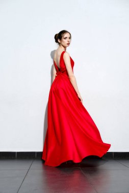 Askılı kırmızı ipek elbisesi olan hoş bir kız.