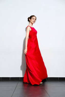 Askılı kırmızı ipek elbisesi olan hoş bir kız.