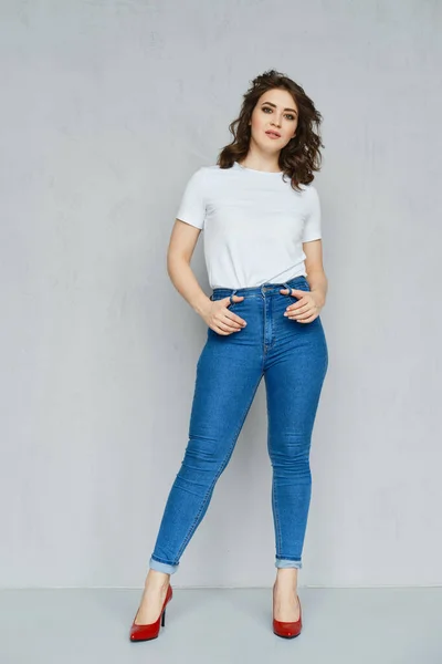 Menina Positiva Jeans Camiseta Branca Estilete Vermelho Posando Perto Parede — Fotografia de Stock