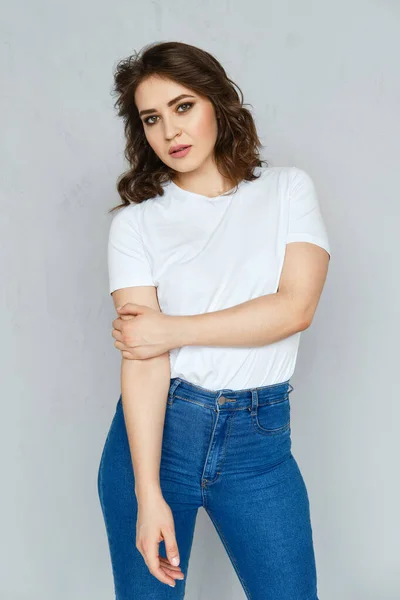 Menina Positiva Jeans Camiseta Branca Estilete Vermelho Posando Perto Parede — Fotografia de Stock